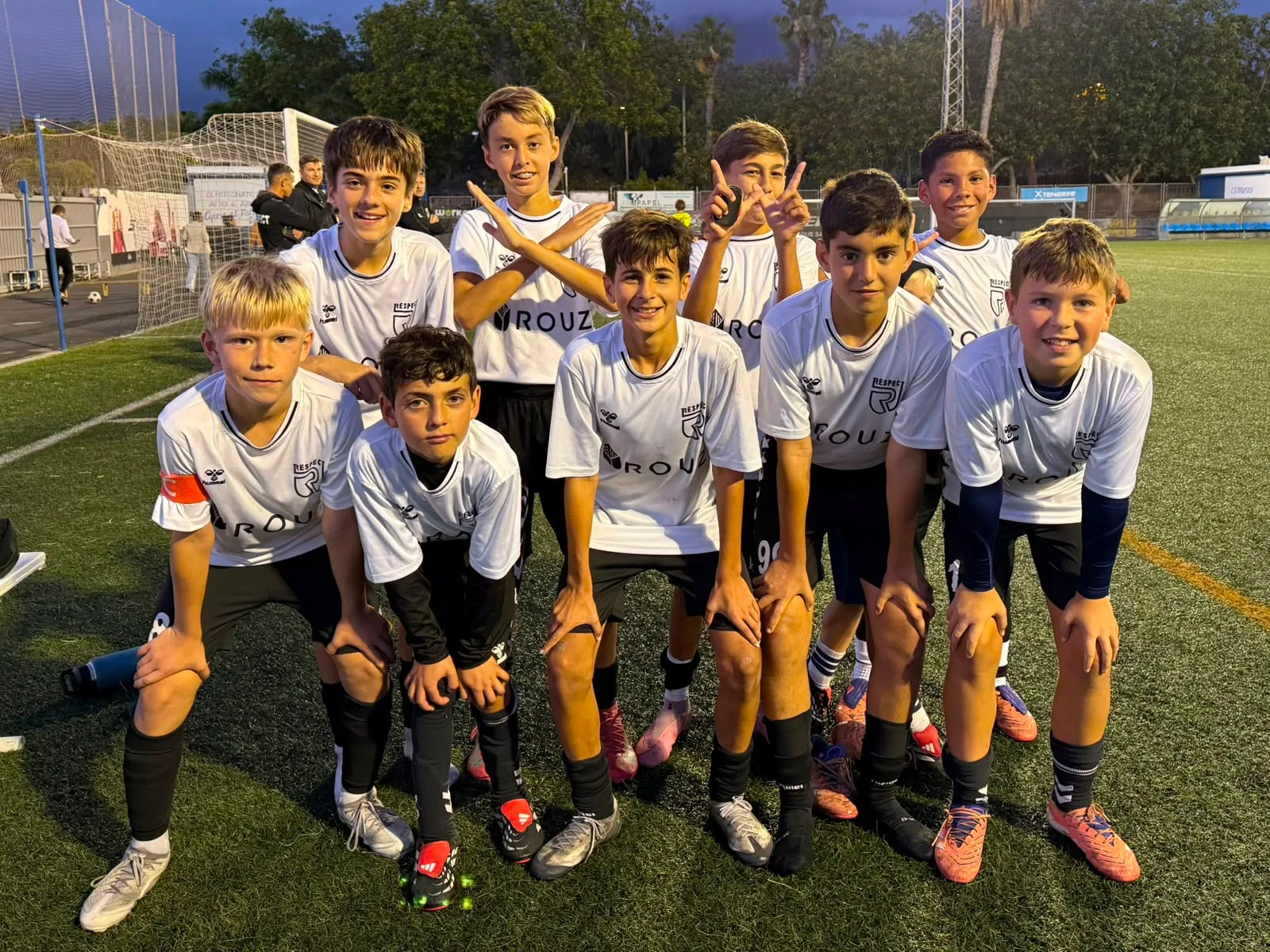 Jugadores jóvenes de Respect Academy con el trofeo y la bandera del club